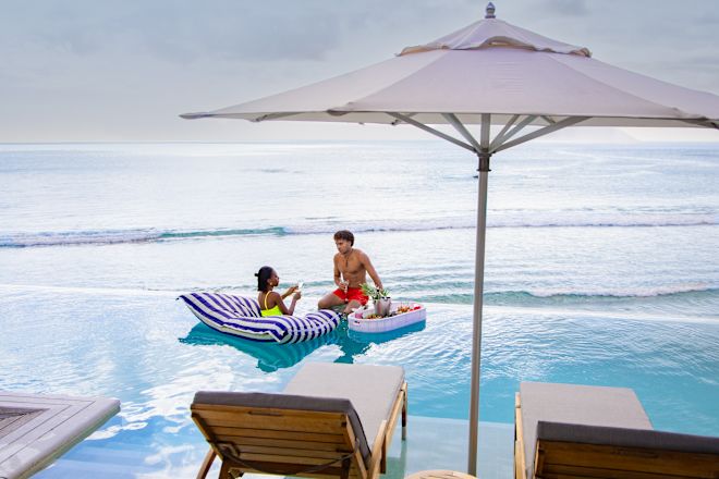Cặp đôi tận hưởng một ngày trong bể bơi ngoài trời với tầm nhìn ra đại dương