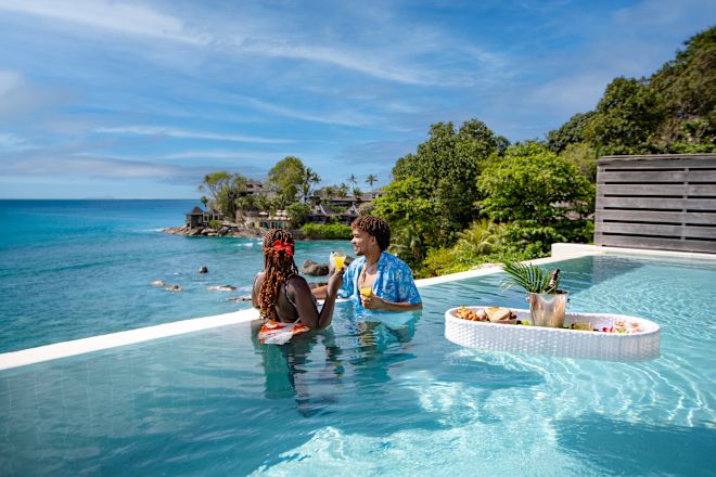Cặp đôi tận hưởng một ngày trong bể bơi ngoài trời với tầm nhìn ra đại dương