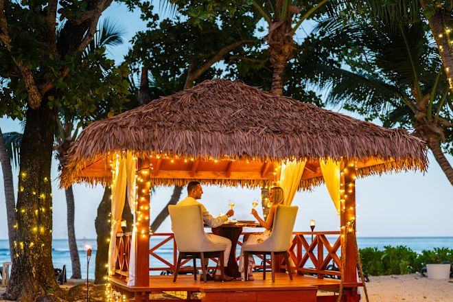 Couple Enjoying a Candlelight Dinner on a Covered Area Outdoors with Views of the Water