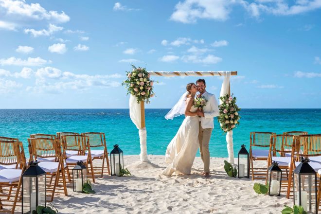 Bride and groom on beach with wedding setup