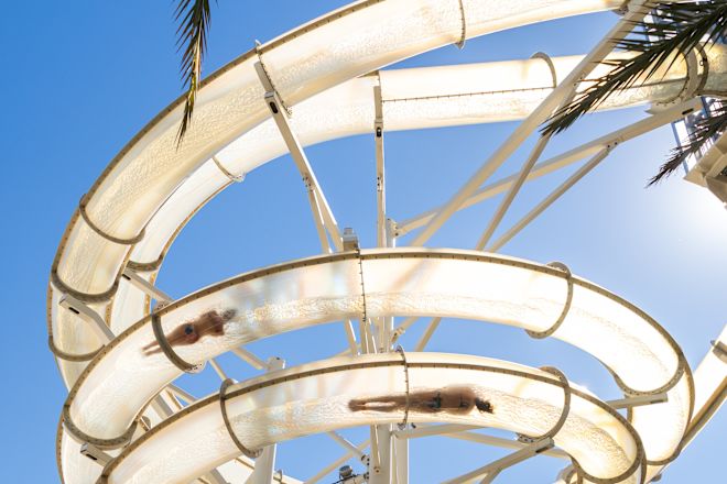 People on a Water Slide in Outdoor Pool Area