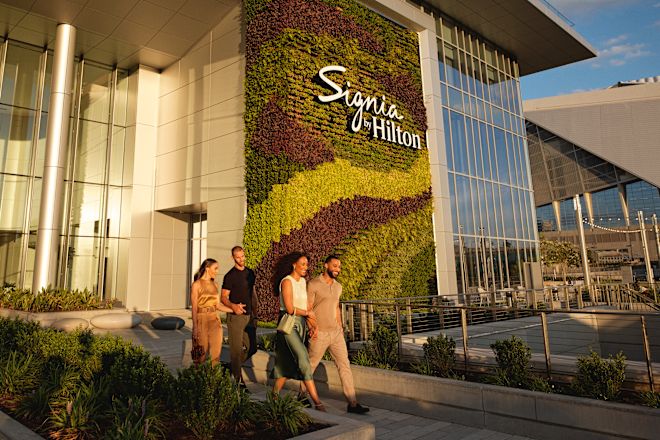 Group of friends leaving hotel, walking past hotel signage