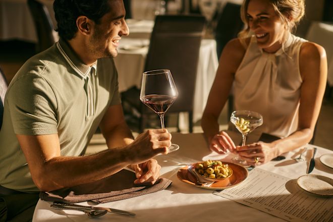 Couple enjoying a drink and meal at a table