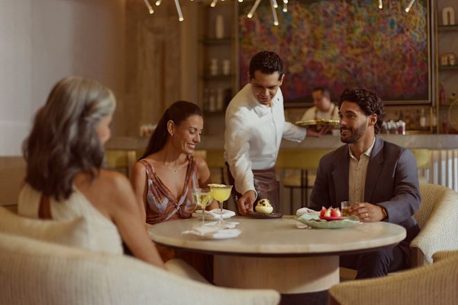 Zwei Frauen und ein Mann bei Drinks und Desserts in der Peacock Alley