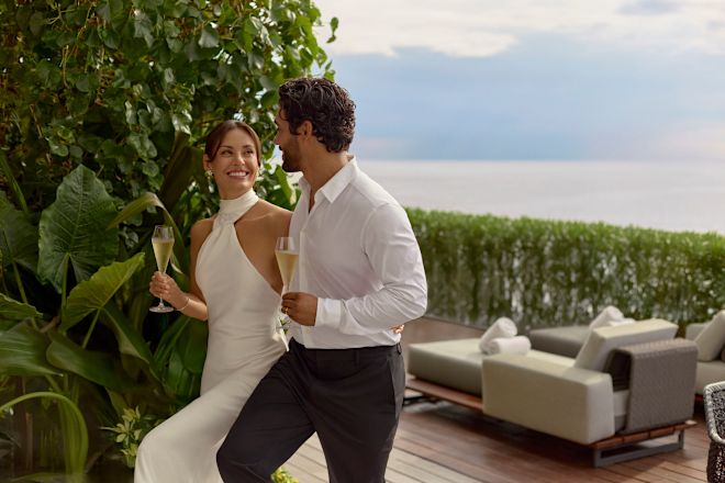 Frau und Mann genießen Champagner auf der Terrasse ihrer Suite
