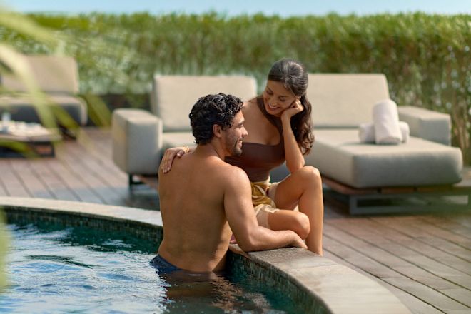 Mann und Frau beim Baden im Swimmingpool ihrer Suite