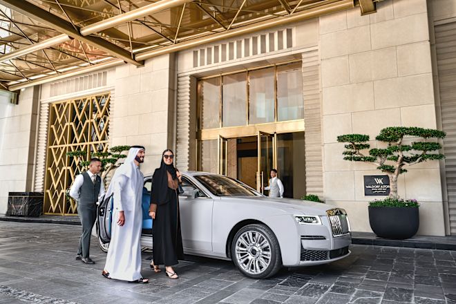 ホテル玄関の車から離れて歩く男女