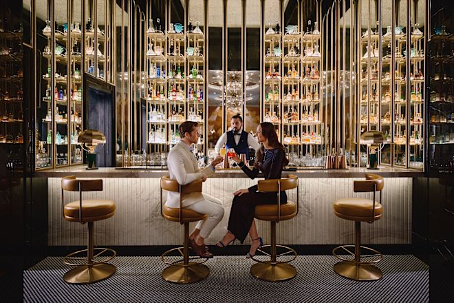 男性と女性がスツールに座っているバーエリア