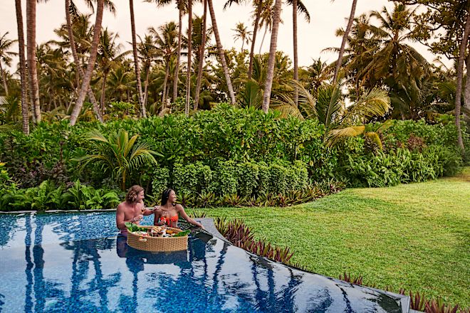 Schwimmendes Frühstück – Mann und Frau im Wasser