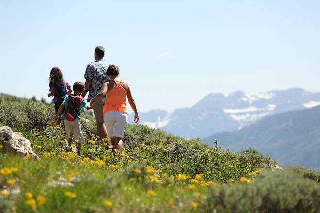 O familie făcând o plimbare pe un munte primăvara