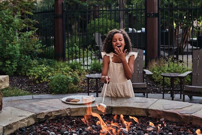 Fată bucurându-se de o plușă într-o curte de pompieri