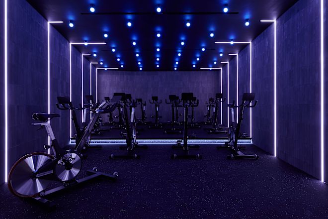 Stationäre Spinning-Bikes im Fitness Center, blaue Beleuchtung