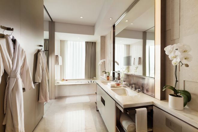 Guestroom Bathroom with Mirror, Dual Vanity, Robes, and Bathtub