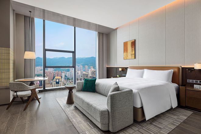 City View from a Guest Room with a Large Bed and Sitting Area