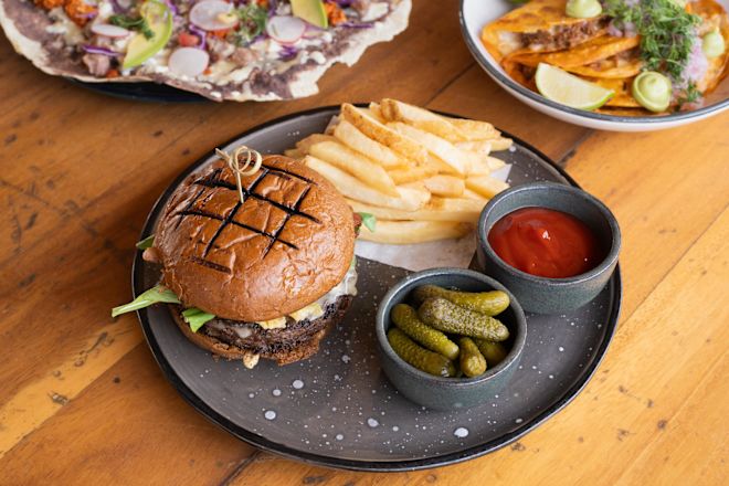 Sandwich, frites, cornichons et sauce sur une table au Carbon Chiringuito