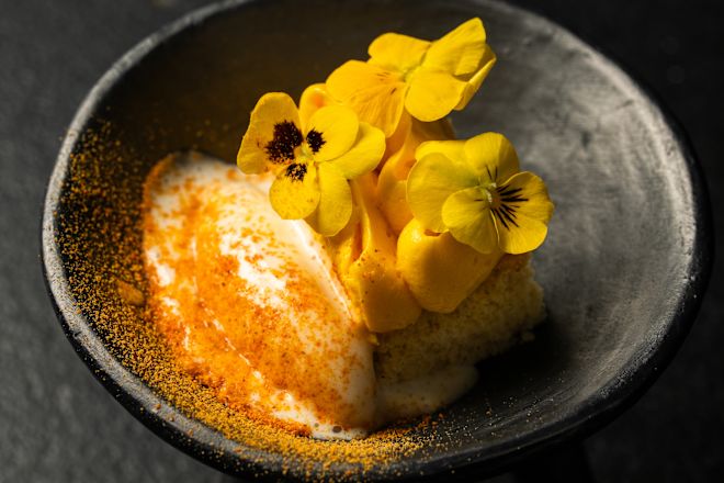 Gericht mit gelben Blumen auf einem Teller im Restaurant "Auto"