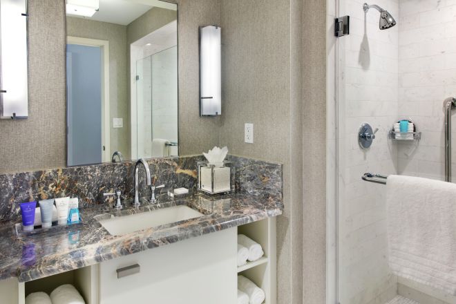 Badezimmer der Suite mit Spiegel, Toilettentisch und begehbarer Dusche