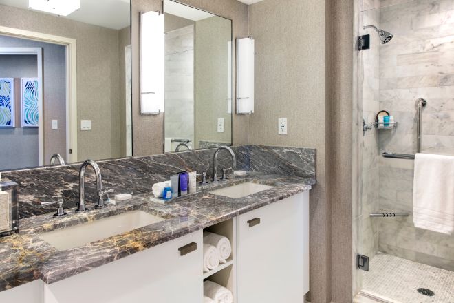 Baño con ducha independiente, espejo, lavamanos y área de tocador