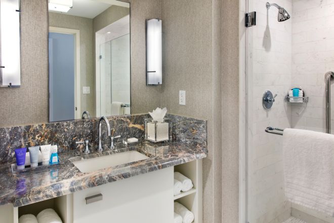 Badezimmer mit Spiegel, Waschbecken, Toilettentisch und begehbarer Dusche