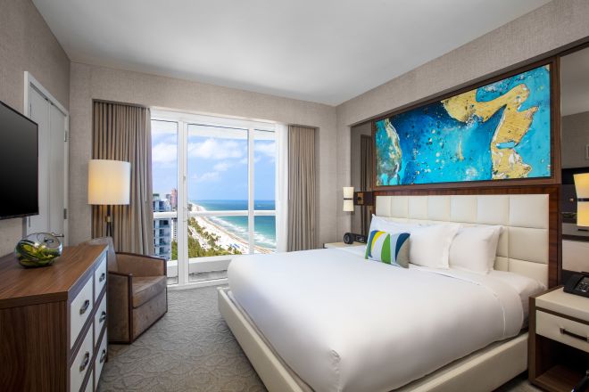 Zimmer mit Kingsize-Bett und Teilblick aufs Meer
