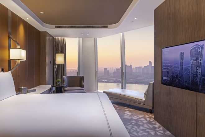 キングベッド1台を配したデラックススイートのベッドルームと眺望