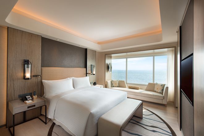 Suite - Camera da letto con divano e ampia finestra con vista sulla baia