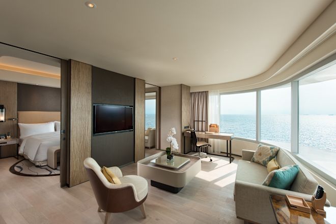 Suite - Soggiorno con ampie finestre e vista sulla baia