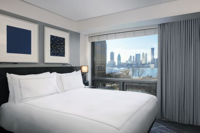 Bed in room with views of skyline