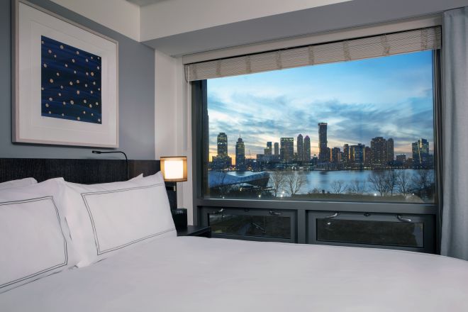 Bed in room with view of Hudson River outside