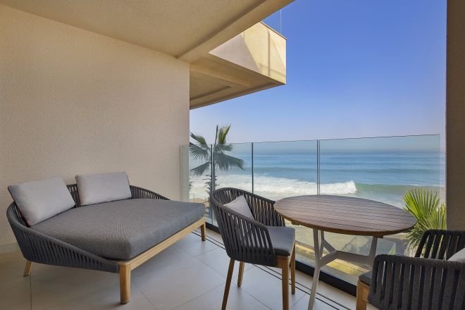 Balkon z miejscem do siedzenia i widokiem na stół i ocean