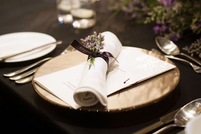 A menu with a folded napkin and lavender laid on top