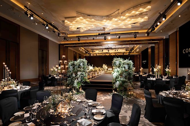 Grand Ballroom decorating for a stunning Wedding. A walkway is surrounded by flowers and elegant tables.