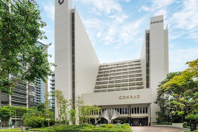 Fasada hotelu z podjazdem i otaczającymi drzewami