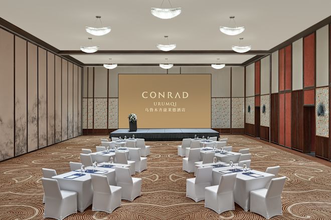 Ballroom with round tables, chairs and projector screen