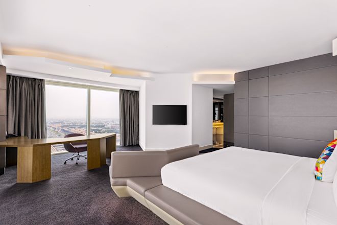 Suite Bedroom with Bed, Work Desk, TV, and City View