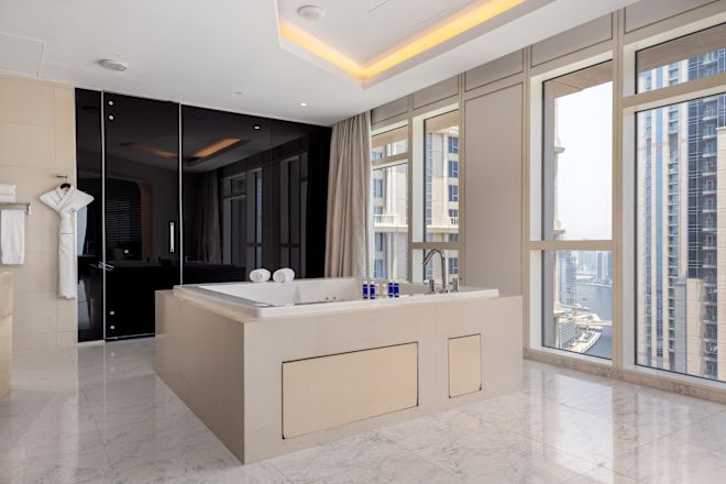 Large stand-alone square tub with floor-to-ceiling windows in the Sky Villa.