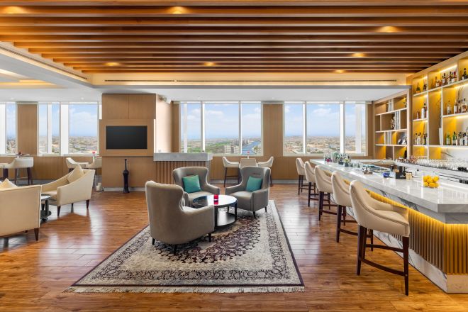 Lounge with bar seating and soft seating areas with outside view.