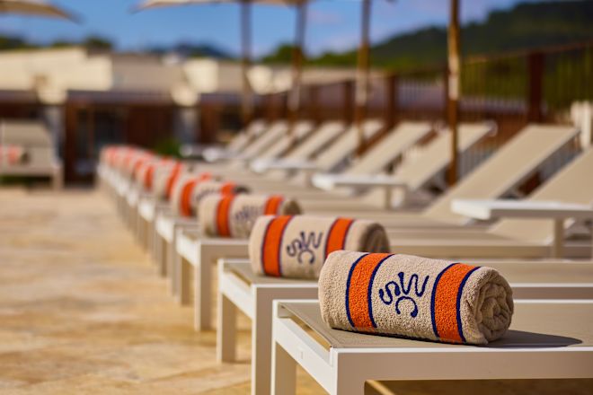 Außenpoolbereich mit Liegestühlen und Handtüchern