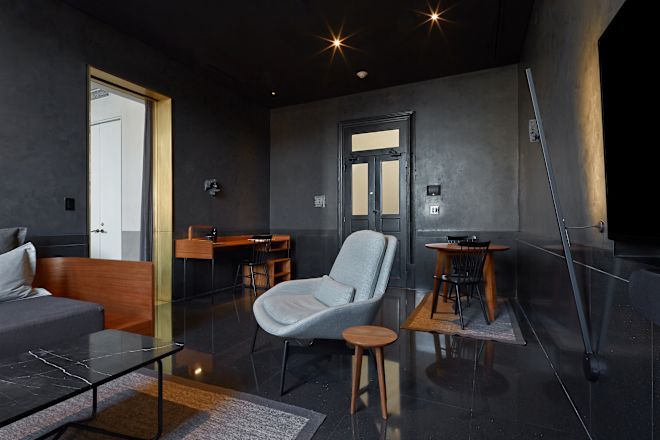 Guestroom lounge area with table, chairs and work desk.