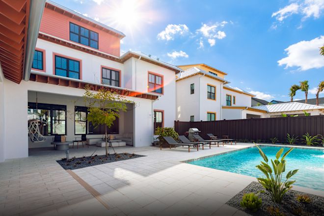 Şezlong, havuz ve ağaçlarla binanın dış görünümü