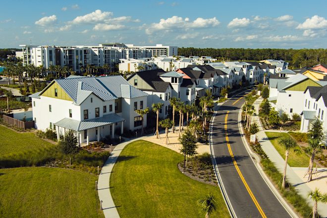 Ağaçlar arasında kıvrılan yol ile bina sırası