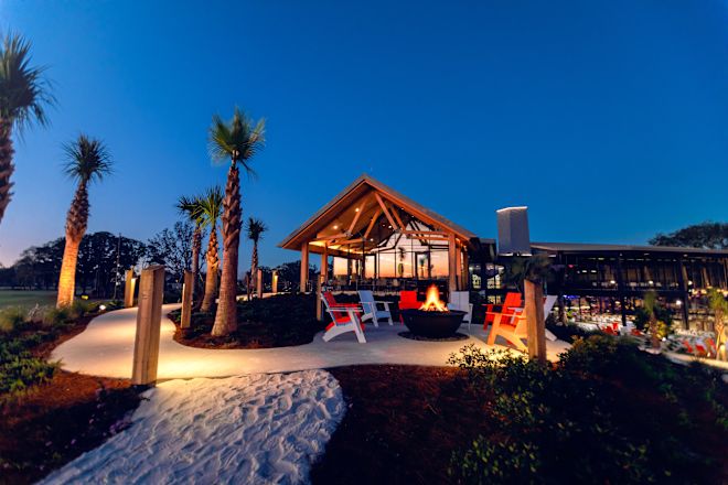 Gün batımında otelin aydınlatma ve palmiye ağaçları ile dışarıdan çekilmiş fotoğrafı