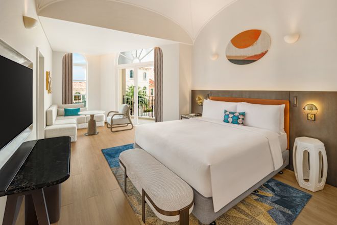 ベッド、リビングエリア、テレビを備えた客室