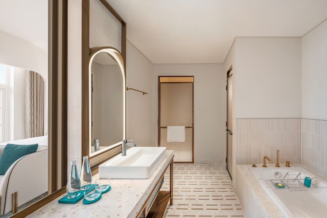 バスタブと洗面台エリアを備えた客室のバスルーム