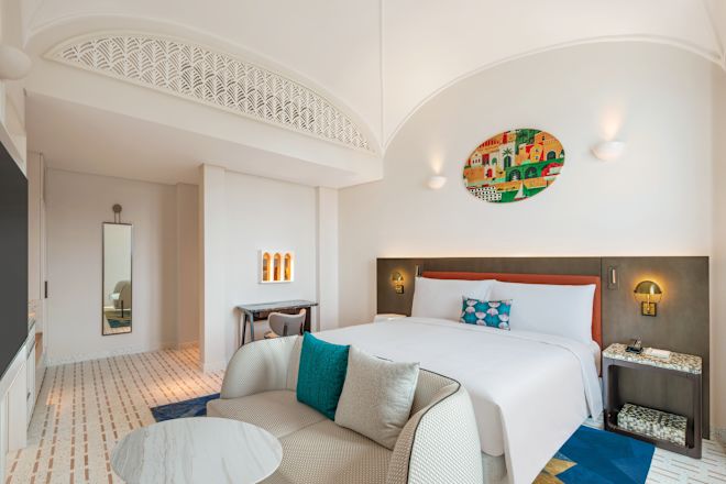 ベッド、リビングエリア、テレビを備えた客室