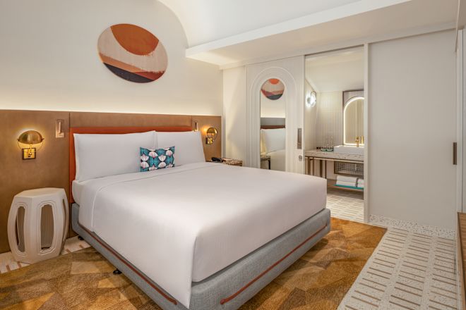 大きなベッドと洗面台エリアを備えた客室