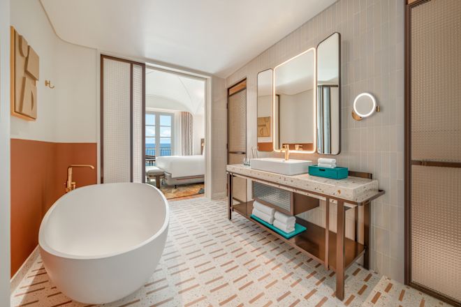 スイートのバスルームと、大きなベッドを配した独立したベッドルームとオーシャンビュー