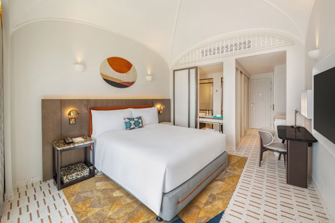 大きなベッド、ワークデスク、ハイビジョンテレビを備えた客室