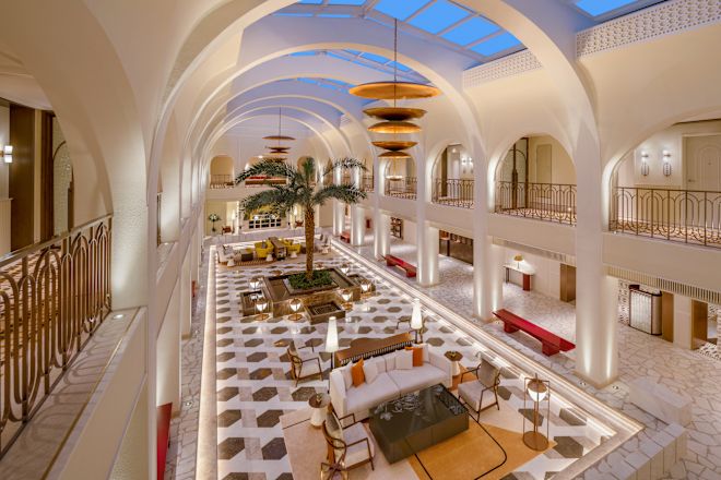 リビングエリア、ヤシの木、ガラスの天井を備えた広いロビー