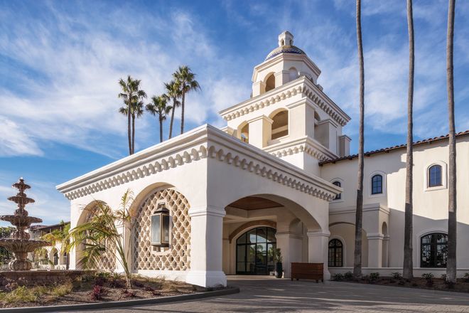 Angle View of Hotel Exterior with Palm Trees and Fountain